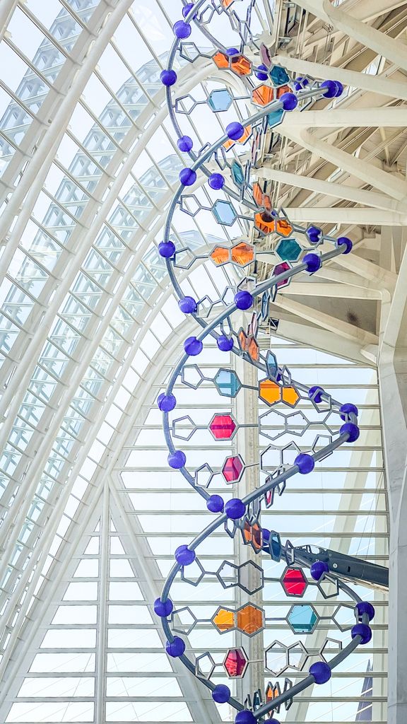 Colorful DNA sculpture inside Valencia's science complex, showcasing modern architecture and art.